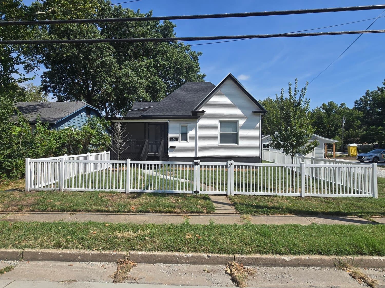 White home with a picket-fenced yard